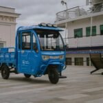 a small blue truck parked in front of a building