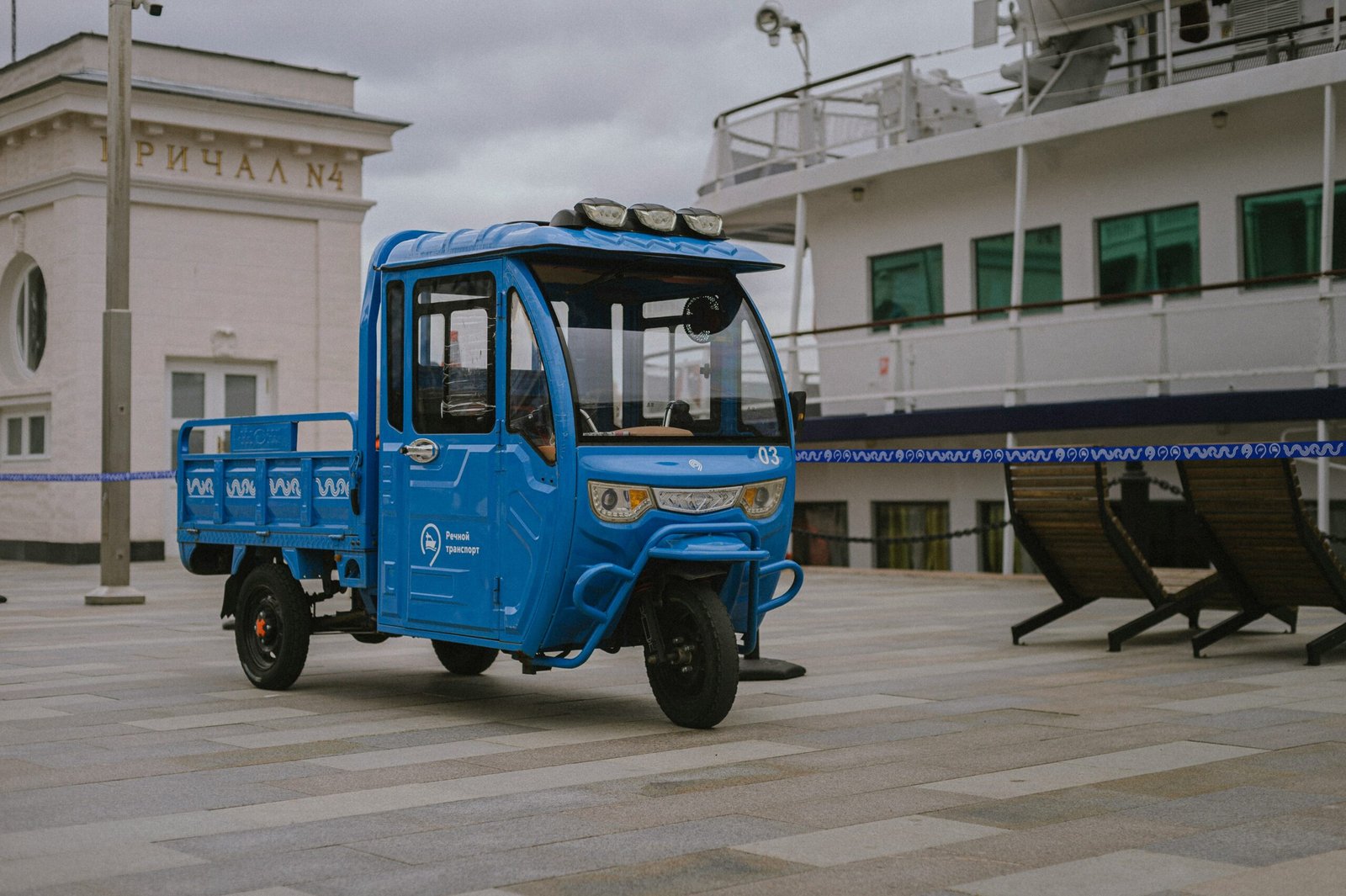 a small blue truck parked in front of a building